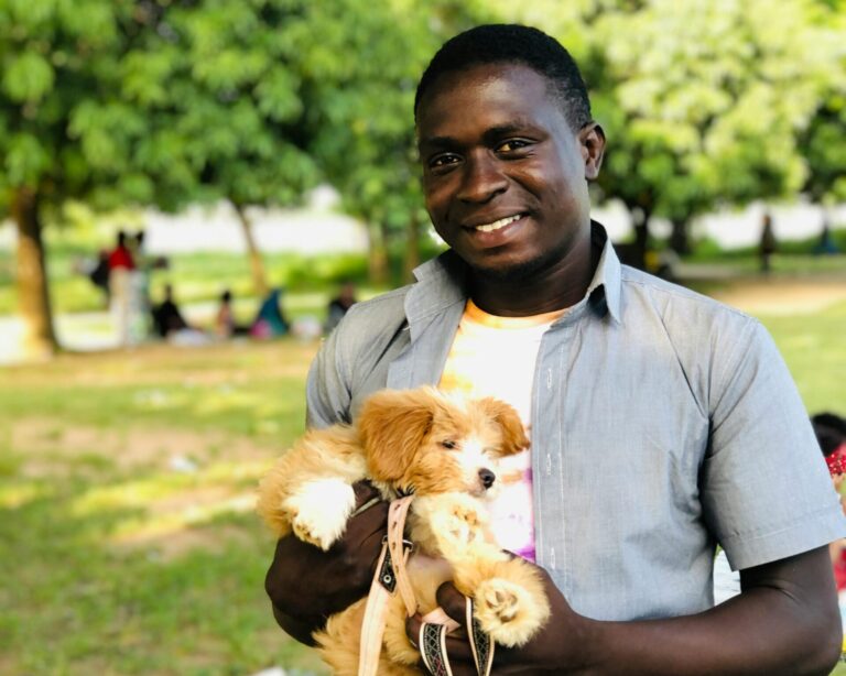 happy black man in park holding his dog